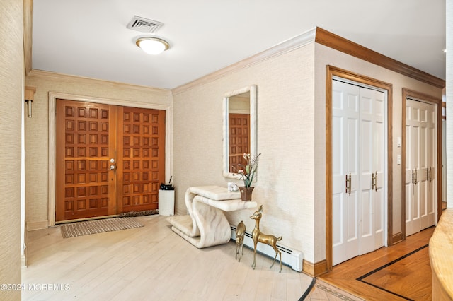 foyer entrance featuring crown molding, hardwood / wood-style flooring, and a baseboard radiator