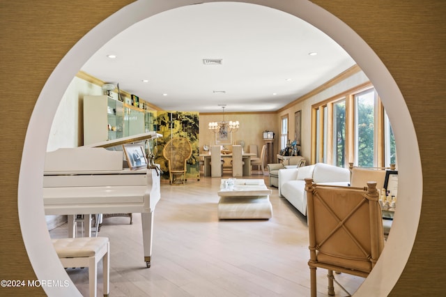 living room featuring an inviting chandelier, crown molding, and light hardwood / wood-style floors