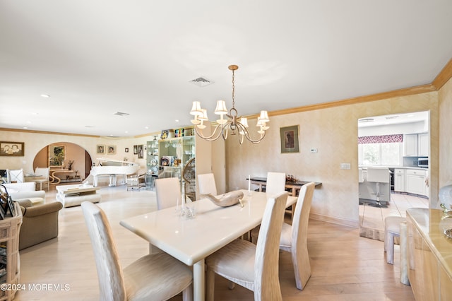 dining room with an inviting chandelier, light hardwood / wood-style flooring, and ornamental molding