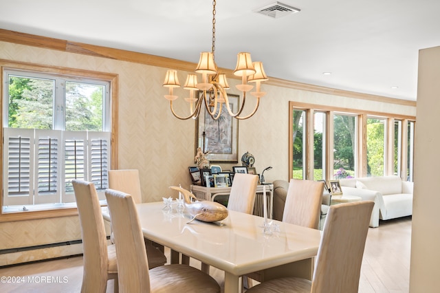 dining area with a chandelier, plenty of natural light, and light wood-type flooring