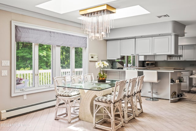 dining space with baseboard heating, a chandelier, light wood-type flooring, and a skylight