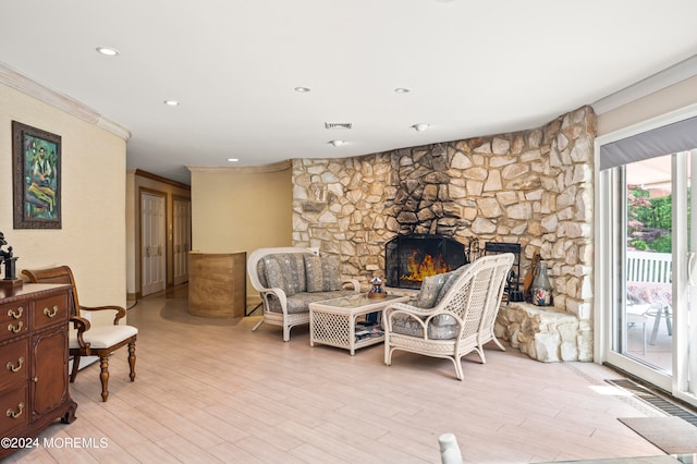 living area featuring ornamental molding, light hardwood / wood-style flooring, and a fireplace