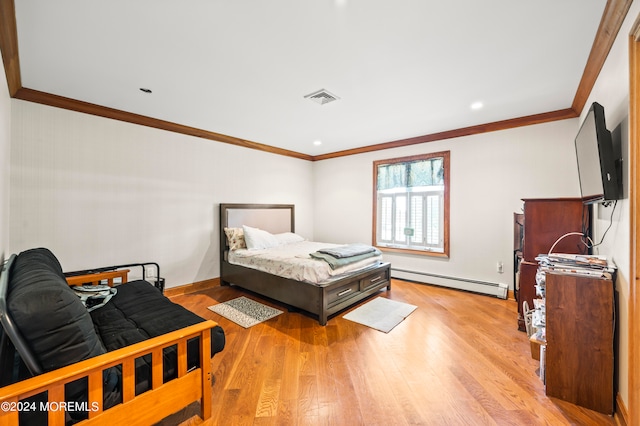 bedroom featuring ornamental molding, a baseboard heating unit, and light wood-type flooring