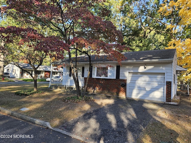 view of front of house with brick siding, aphalt driveway, and an attached garage