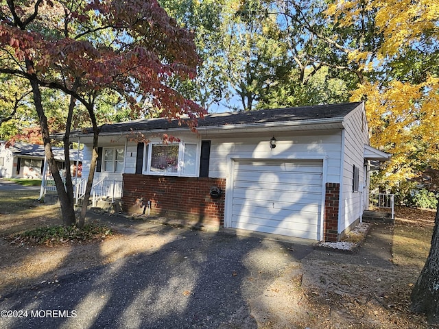 view of front of home with a garage, brick siding, and aphalt driveway