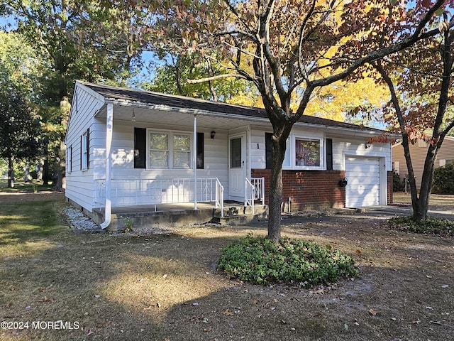 view of front of house featuring a porch, a garage, and brick siding