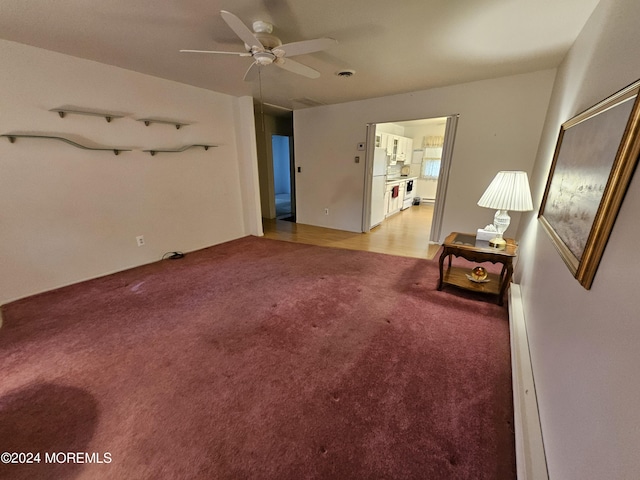 unfurnished living room with light colored carpet and a ceiling fan