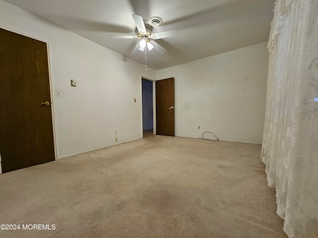 unfurnished room featuring light carpet and ceiling fan