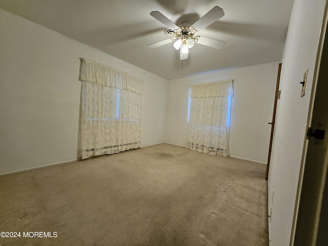 unfurnished bedroom with a ceiling fan, baseboard heating, carpet floors, and baseboards