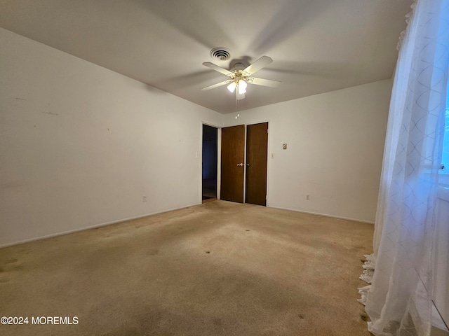 spare room with light colored carpet and ceiling fan