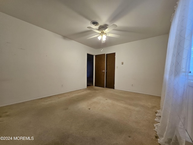 unfurnished bedroom with visible vents, a ceiling fan, baseboards, and light carpet