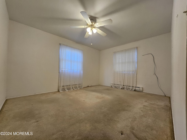 carpeted spare room with a baseboard heating unit and a ceiling fan