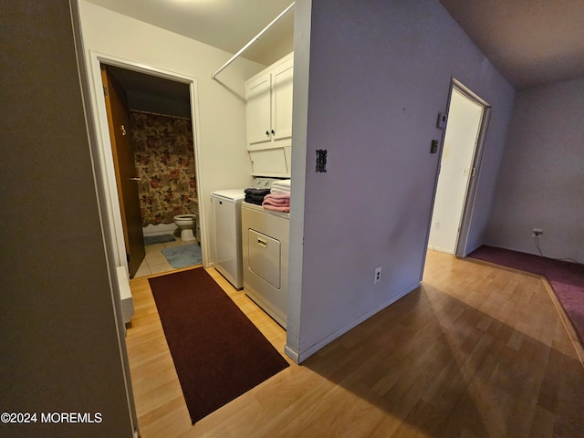 laundry area featuring light hardwood / wood-style flooring and washing machine and clothes dryer