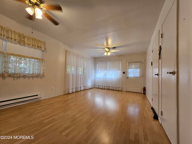 interior space with light hardwood / wood-style floors, baseboard heating, and ceiling fan