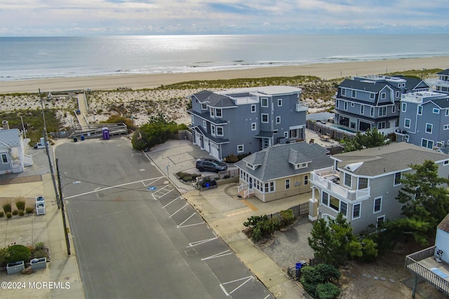 birds eye view of property with a water view and a beach view