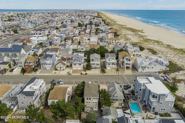 birds eye view of property with a water view and a beach view