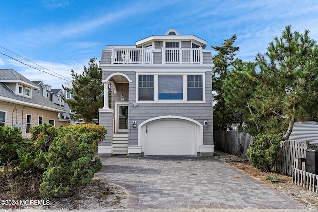 view of front of property featuring a balcony and a garage