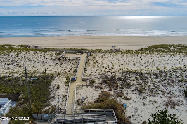 birds eye view of property with a water view and a beach view