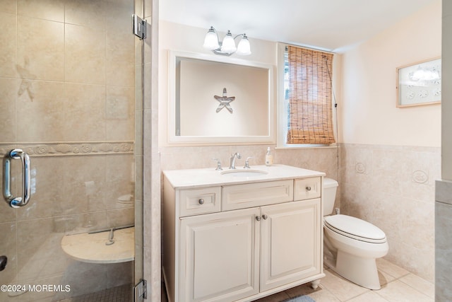 bathroom featuring tile walls, toilet, vanity, an enclosed shower, and tile patterned flooring