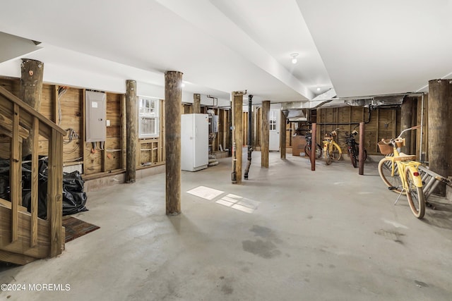 basement with electric panel and white fridge