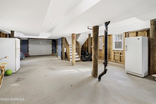 garage with electric panel and white refrigerator