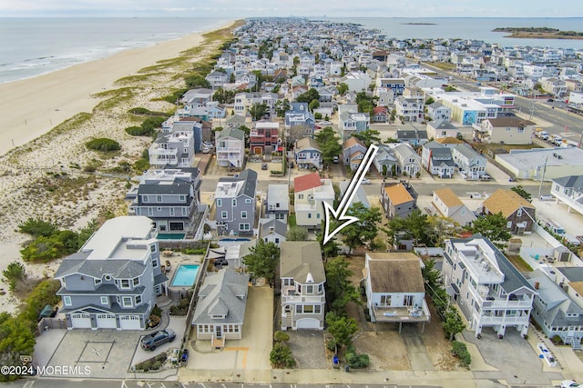 birds eye view of property featuring a water view and a beach view