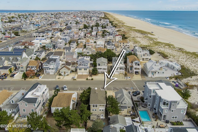 birds eye view of property with a water view and a beach view