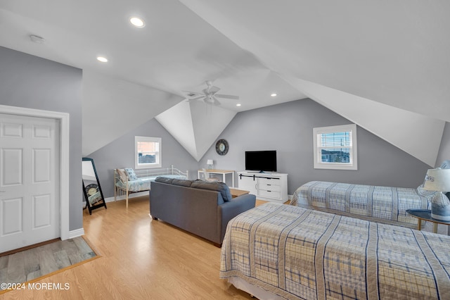 bedroom with ceiling fan, vaulted ceiling, multiple windows, and light wood-type flooring