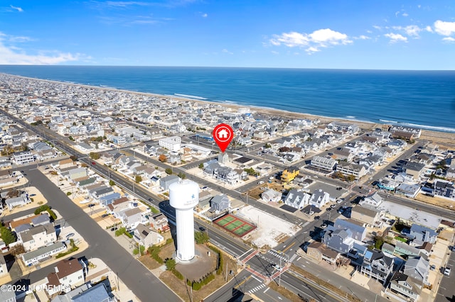 birds eye view of property with a water view and a beach view