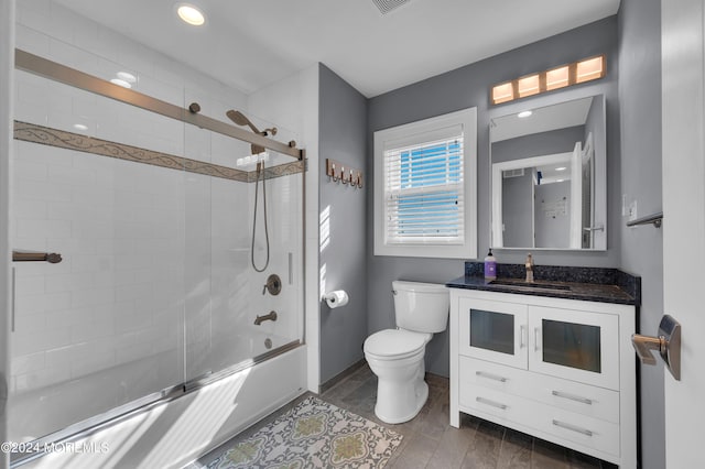 full bathroom featuring vanity, enclosed tub / shower combo, toilet, and hardwood / wood-style floors