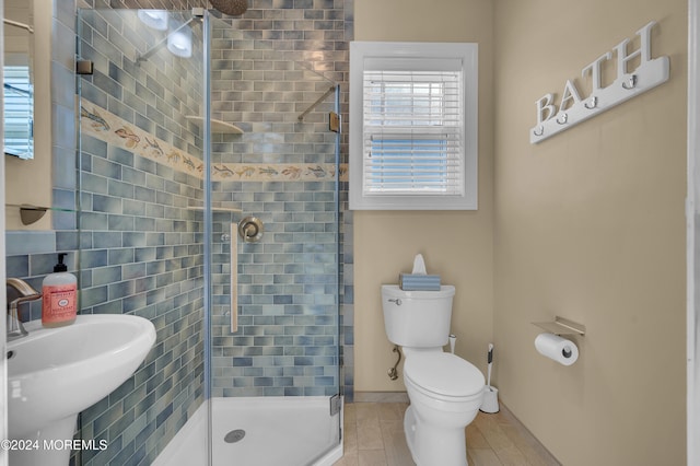 bathroom featuring toilet, sink, and an enclosed shower