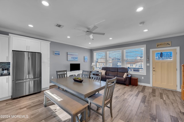 dining room with ceiling fan, crown molding, and light wood-type flooring