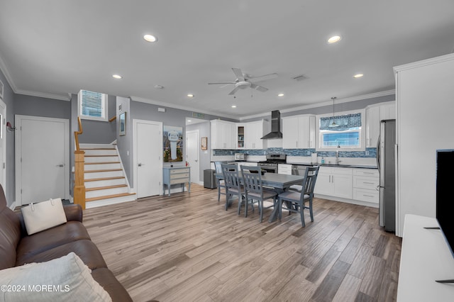 dining area featuring crown molding, light hardwood / wood-style floors, and ceiling fan