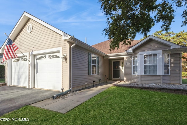 ranch-style house featuring a front lawn and a garage