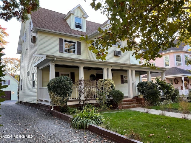 view of front of home featuring a porch, a front lawn, and a garage