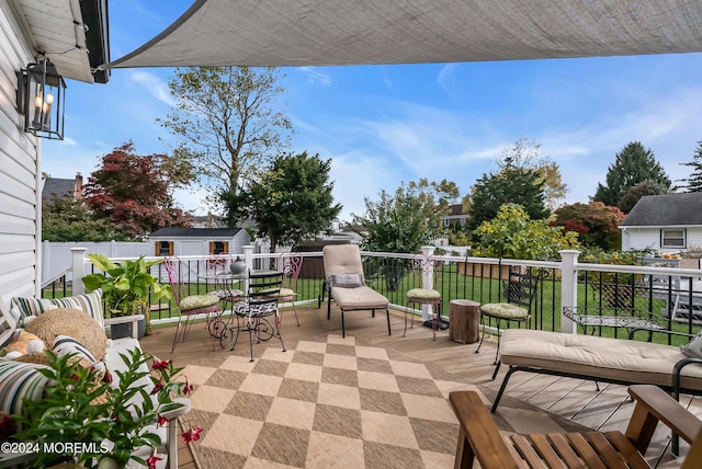 view of patio / terrace with a wooden deck and a storage shed