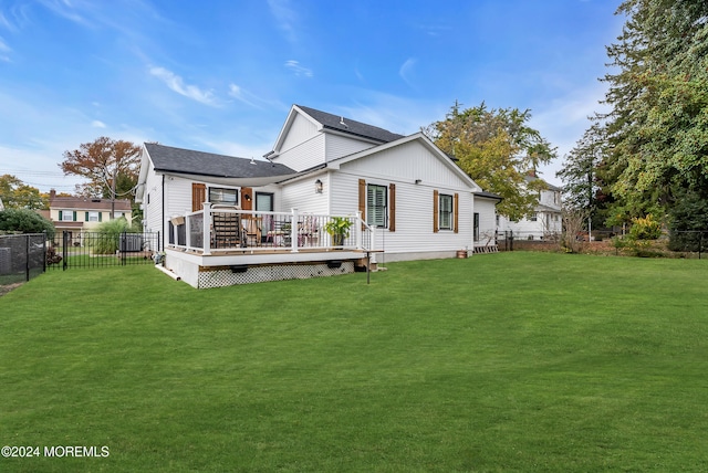 back of house with a deck and a yard