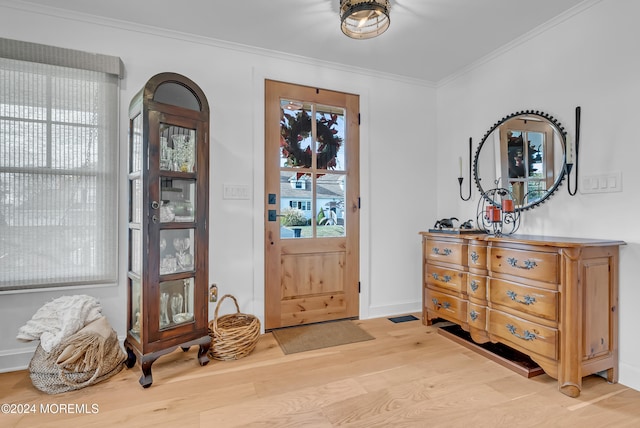 entrance foyer with light hardwood / wood-style flooring and crown molding