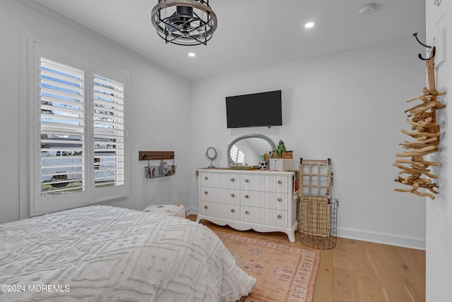 bedroom with multiple windows, light wood-type flooring, and ornamental molding