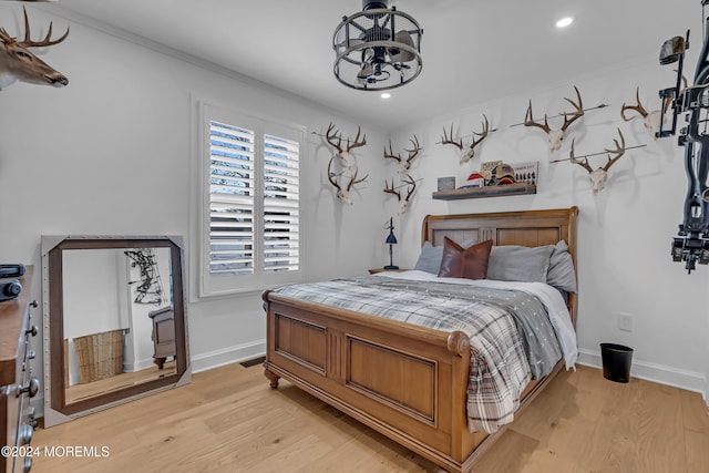 bedroom featuring ornamental molding and light hardwood / wood-style floors