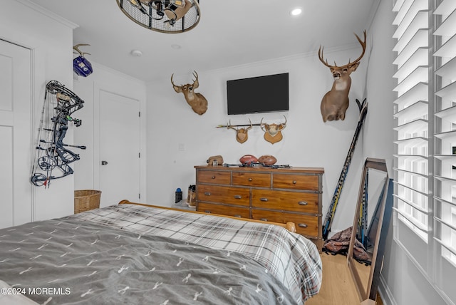 bedroom featuring wood-type flooring and crown molding