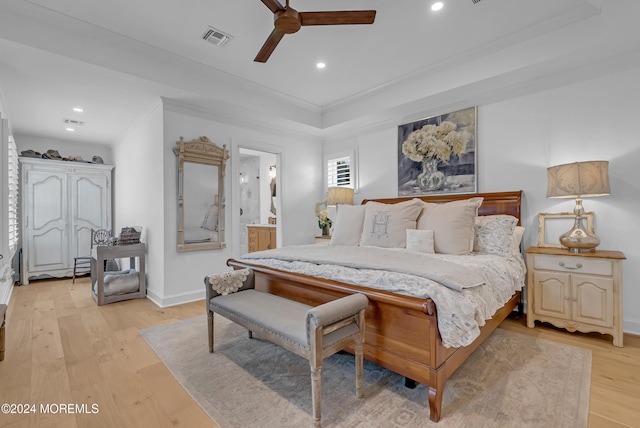 bedroom with light hardwood / wood-style floors, ceiling fan, crown molding, and connected bathroom