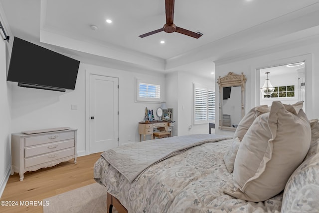 bedroom with ceiling fan, multiple windows, and light hardwood / wood-style floors