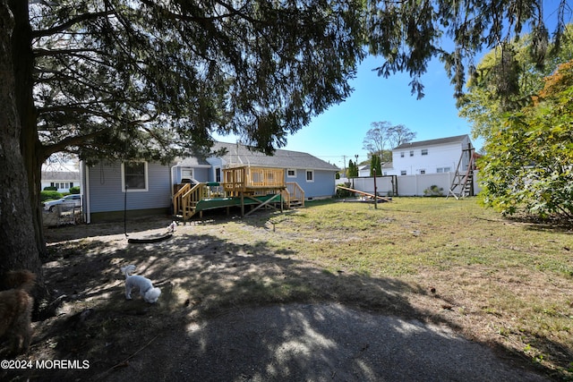 back of house featuring a lawn and a deck