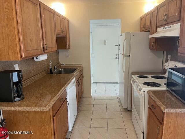 kitchen featuring white appliances, sink, backsplash, custom range hood, and light tile patterned floors