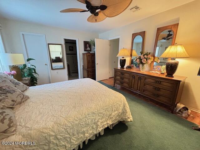 carpeted bedroom with a ceiling fan and visible vents