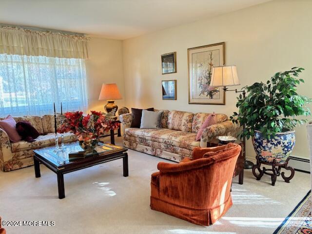 living area featuring a baseboard heating unit and carpet