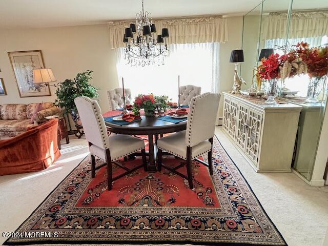 dining space featuring a notable chandelier and light carpet