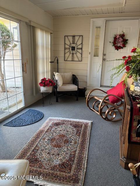 interior space with carpet flooring and wooden walls