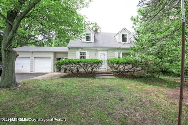 new england style home featuring a garage and a front lawn